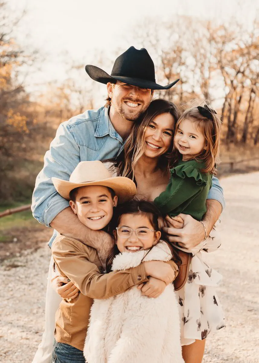 A family of six laughing together outdoors